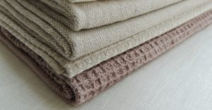 Stack of folded beige and brown rugs